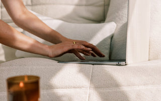 cozy entrepreneur woman typing on laptop with a cozy couch and candle