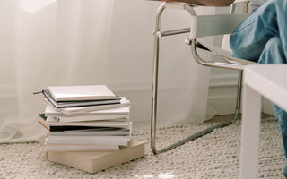 woman with coffee and stacks of books